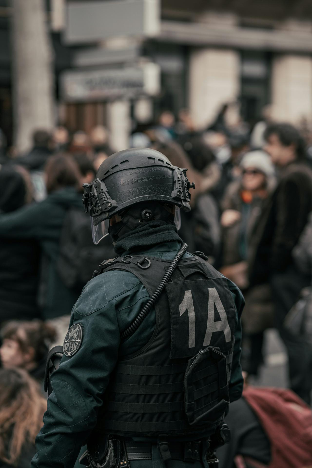 Policeman standing in front of a crowd in Paris during the protests against Macron’s gouvernement use of the law 49.3 